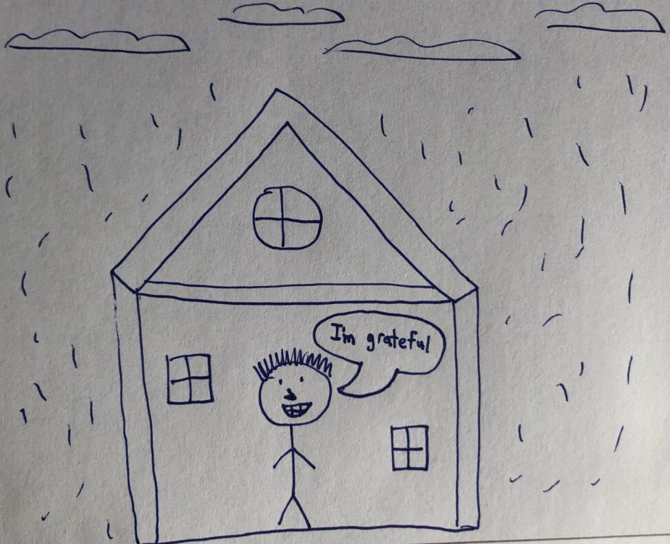 There is a boy in his house being grateful that he is not getting rained on.