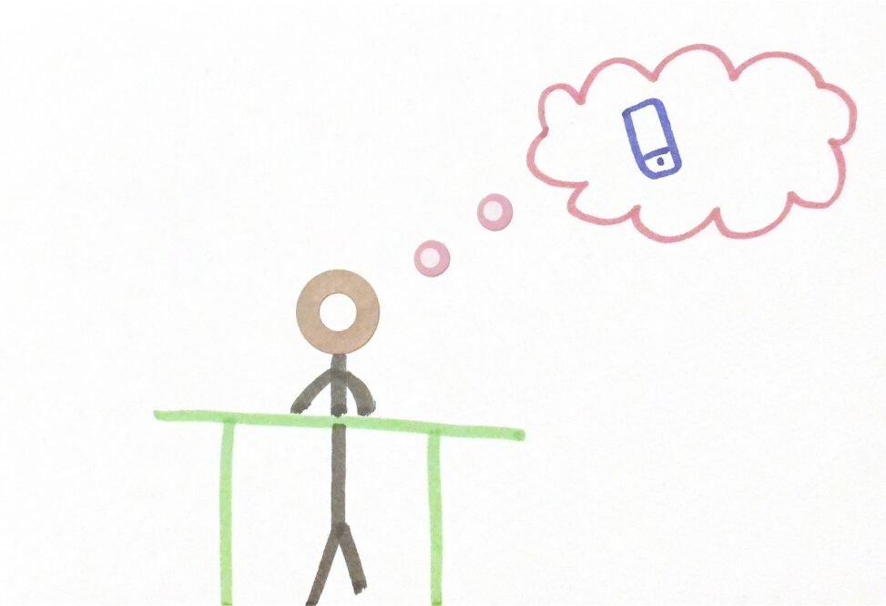 Stick figure stands at a desk thinking about their cellphone as they cannot use it and need to do homework.