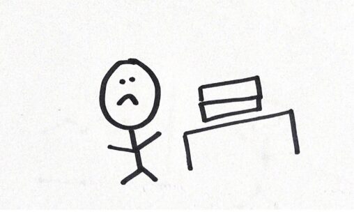 Unhappy stick figure person with desk with books on top of it.