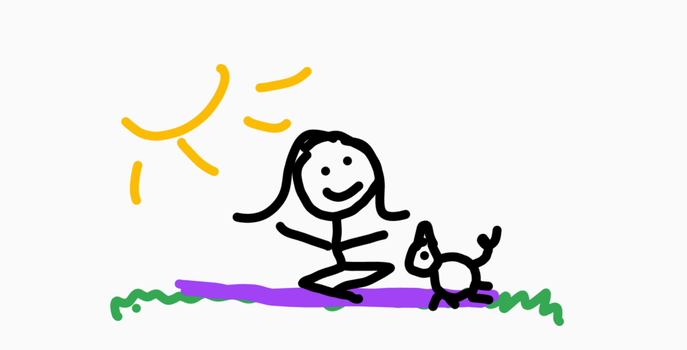 Girl sitting on blanket on grass with dog next to her. It is a beautiful day. She is smiling.